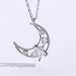 Macro detail of star and crescent moon pendant with sparkling zircon in silver finish