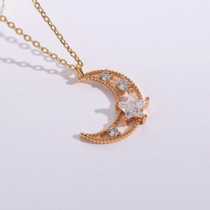 Detailed view of 14K gold plated crescent moon and star pendant with cubic zirconia