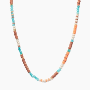 Gros plan d'un collier bohème fait main avec des perles Heishi turquoise, corail et blanches