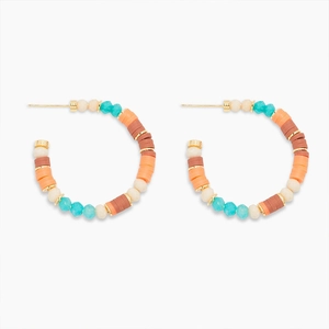 Détail de créoles bohèmes avec des perles colorées turquoise et orange et clous dorés