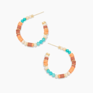 Détail de créoles bohèmes avec perles colorées turquoise et orange et espaceurs dorés