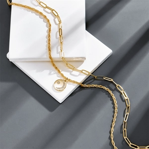 Double-layered gold paperclip and rope chain necklace with a crescent moon and star pendant