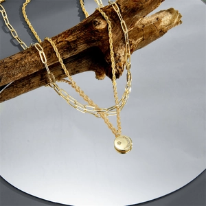 Double-layered gold necklace with moon pendant, twisted chain and paperclip link design
