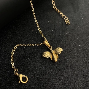 Détail du collier pendentif abeille dorée montrant la texture et le fermoir mousqueton