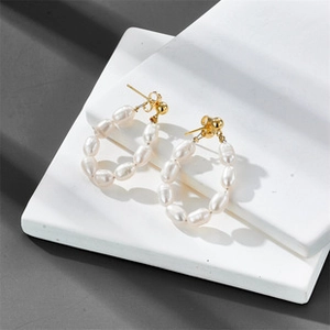 Detail of freshwater pearl drop earrings with 14K gold plated U-shaped frames