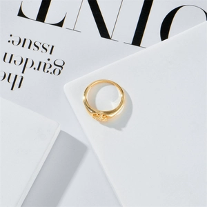 Exquisito anillo de mariposa dorado con detalles florales sobre fondo estético minimalista
