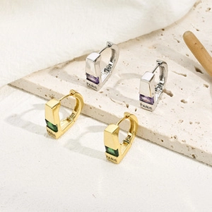 Detail von Gold- und Silber-Creolen mit quadratischem Zirkon und Paris-Gravur