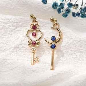 Makro-Detail asymmetrischer Sailor Moon Ohrringe mit rosa Herz und blauem Mondanhänger