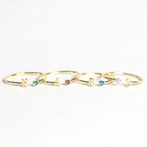 Detailed macro shot of adjustable gold rings with colorful zircons and letters N A B S