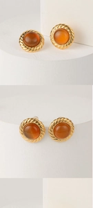 Nahaufnahme der Vintage-Bernstein-Ohrstecker mit 14K Goldrand auf weißem Ständer
