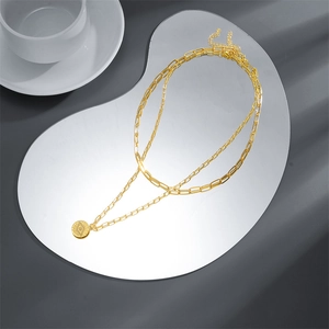 Double-layered gold paperclip chain necklace with a bohemian evil eye pendant