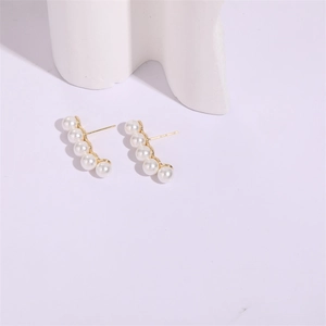 Minimalist gold curved ear climbers with gradient white pearls on white background