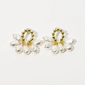 Detailed view of fan-shaped drop earrings with golden beads and five white teardrop pearls