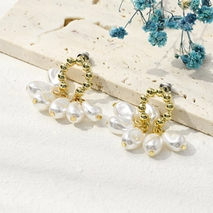 Detailed view of elegant gold pearl earrings with a fan-shaped baroque pearl design
