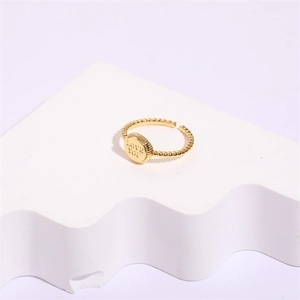Detail shot of golden letter ring with LOVE YOU engraving and beaded band texture