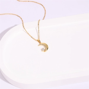 Gros plan d'un collier lune plaqué or 14K avec zircons pavés et pendentif étoile
