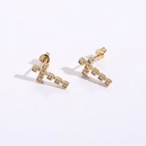 Détail de boucles d'oreilles croix plaquées or 18 carats avec incrustations de zircon