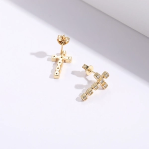 Vue détaillée de boucles d'oreilles croix dorées serties de zircons avec fermoir papillon