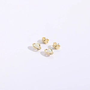 Macro view of gold Saturn stud earrings with opal-like stone and butterfly back