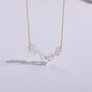 Detalle de collar con colgante de cristal de cuarzo natural y fina cadena dorada