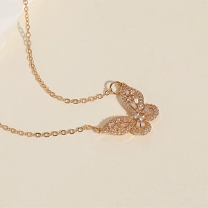 Macro shot of gold-plated butterfly pendant necklace featuring sparkling white zircon stones