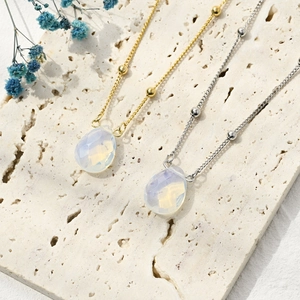 Detailed view of teardrop opal pendants on satellite chains in gold and silver finish