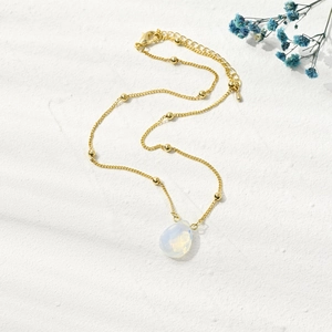 Detailed view of a gold satellite chain featuring an elegant white opal teardrop pendant
