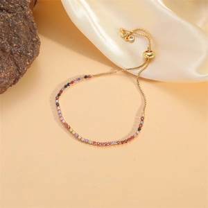 Détail des pierres en zircone arc-en-ciel et fermoir coulissant ajustable en or 14K sur gourmette