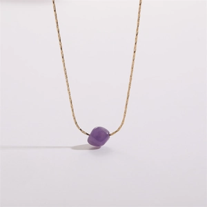 Detail of a thin gold snake chain featuring a teardrop amethyst quartz stone pendant