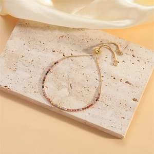 Détail du bracelet ajustable plaqué or 14K avec zircon sur fond en pierre texturée