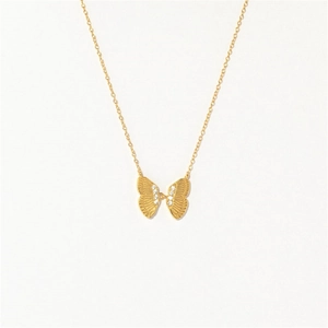Macro detail of a 14K gold butterfly pendant featuring intricate texture and zircon stones