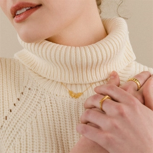 Elegant 14K gold butterfly necklace with zircon pendant and minimalist rings set on a model