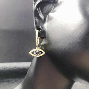 Detail of 14K gold evil eye hoop earrings with blue zircon and micro-pave white stones