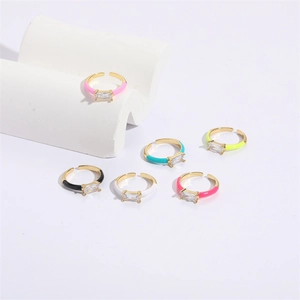 Close-up of square zircon rings with colorful enamel finishes on gold plated bands