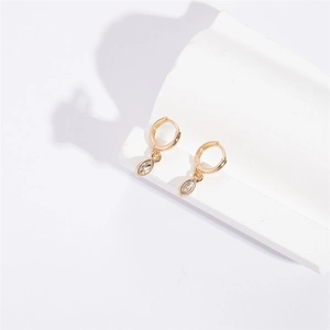 Detail of gold geometric earrings with marquise zircon on a minimalist white pedestal