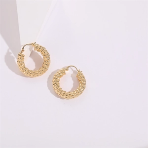 Macro detail of gold chunky hoop earrings with textured woven pattern and clasp closure