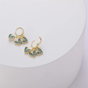 Detail of 14K gold hoop earrings with three turquoise heart charms on a white display