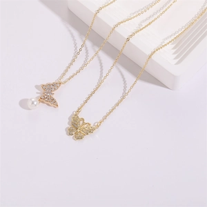 Detailed macro of gold butterfly necklaces with pearls and shimmering zircon stones