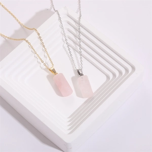 Colliers minimalistes en or et argent avec pendentifs en quartz rose sur socle blanc