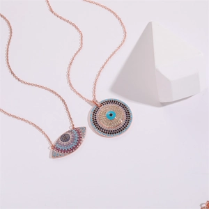 Parure de colliers œil maléfique en or rose avec zircons colorés sur fond minimaliste