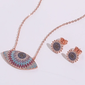 Vue macro d'un ensemble collier et boucles d'oreilles œil porte-bonheur en or rose