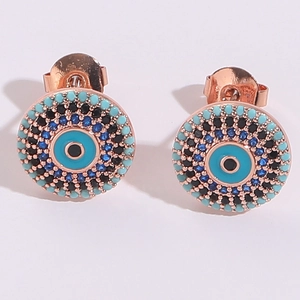 Gros plan de boucles d'oreilles œil porte-bonheur en or rose avec zircons bleus et turquoises