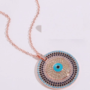 Détail macro du pendentif œil maléfique en or rose avec cristaux de turquoise et zircon