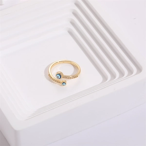 Detailed top view of gold Evil Eye ring with pavé zircons on white tiered display