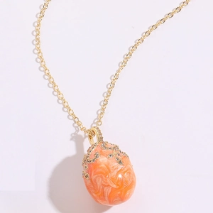 Detail of egg-shaped enamel pendant necklace with gold plating and crystal accents