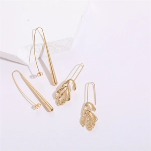 Detail view of gold leaf and long water drop earrings with brushed metal texture
