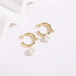 Lava texture gold hoop earrings with white round pearls on minimalist white background