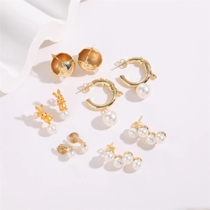 Detailed set of gold bunny and pearl C-shaped earrings with geometric stud designs