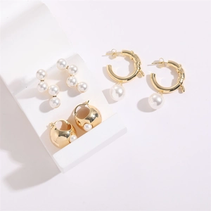 Detailed view of three gold-plated earrings set featuring pearls and geometric C-shapes