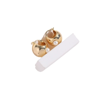 Golden chunky hoop earrings with white pearl inlay and French clip on white backdrop